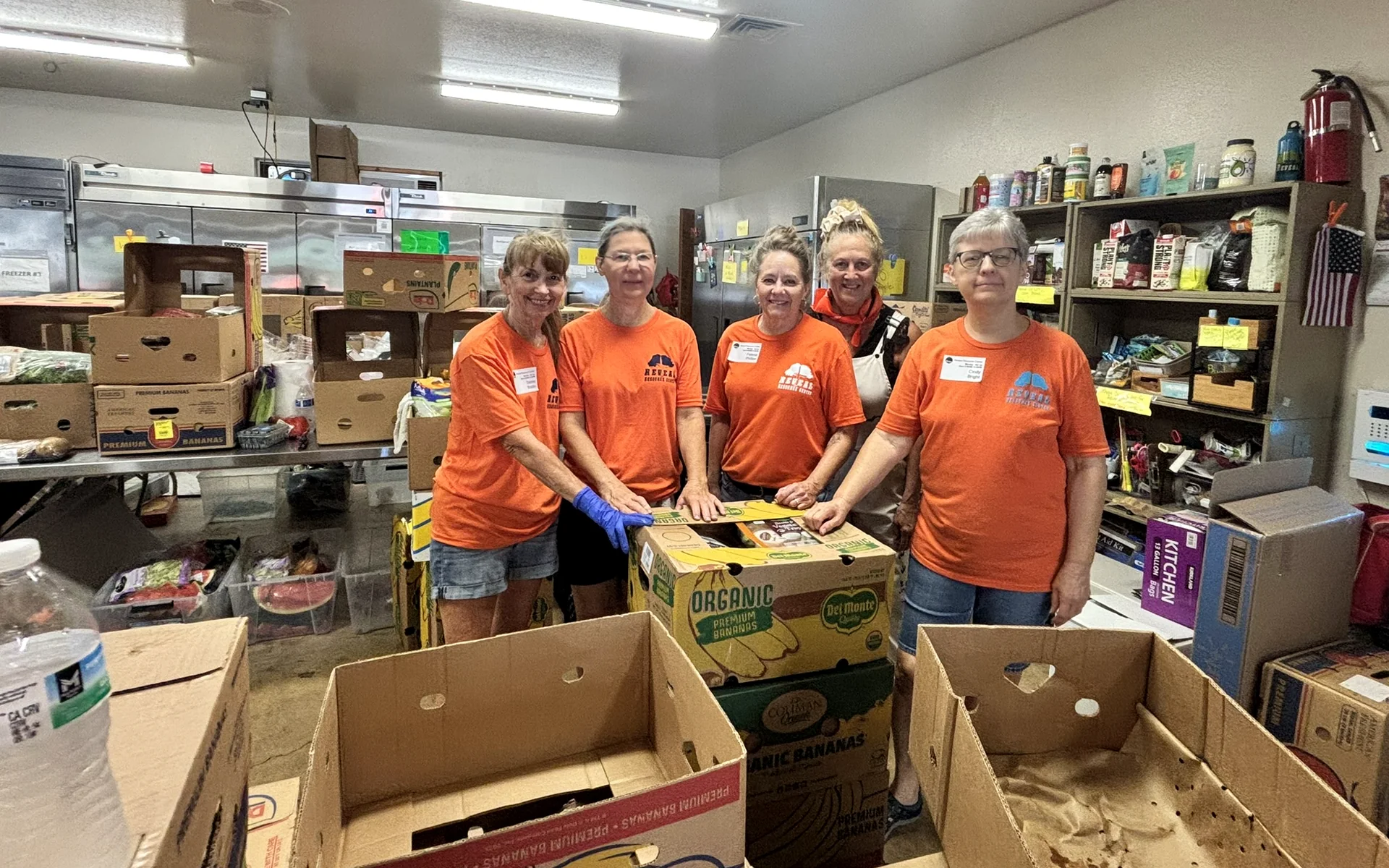 Reveal volunteers sorting and organizing food donations in the pantry.